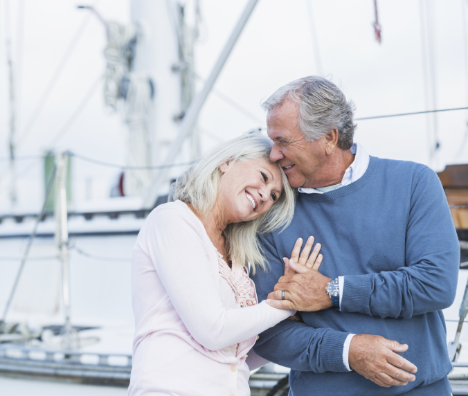 A man and woman embracing on the deck of a boat.